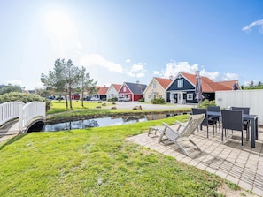 Un quartier résidentiel avec des maisons, un petit étang et un pont.