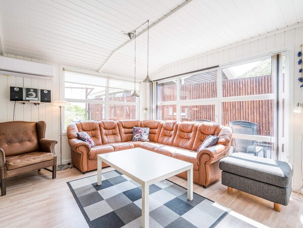 A spacious living area with a leather sectional sofa, a small table, and a bench.