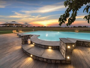 A swimming pool with a stone deck, surrounded by lounge chairs and a sunset view. - Rustic Farmhouse in Lazio (Castiglione in Teverina)