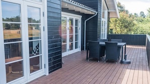 A deck with outdoor furniture and sliding glass doors.