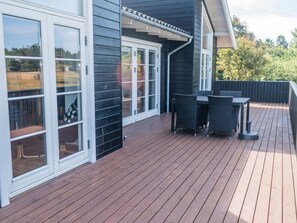 A deck with outdoor furniture and sliding glass doors.