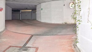 An empty parking garage with concrete walls, a tiled floor, and a green exit sign. - Vibrant Holiday Home in Lazise with Swimming Pool near 2 Lakes (Lazise)