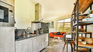 A modern kitchen with a built-in microwave, stainless steel sink, and a range hood. - Holiday Home in Tripscompagnie Near Nature (Tripscompagnie)