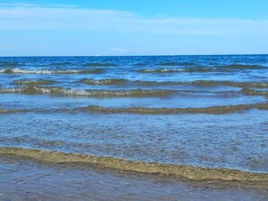 Ein Strand mit Wellen und blauem Himmel.