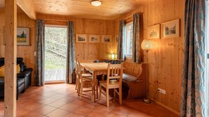 Un intérieur en bois comprenant une table à manger, des chaises, un canapé et une lampe.