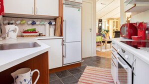 A modern kitchen with white cabinets, a built-in refrigerator, a microwave, and a stove. - 6 Person Holiday Home in Gilleleje-by Traum (Gilleleje)