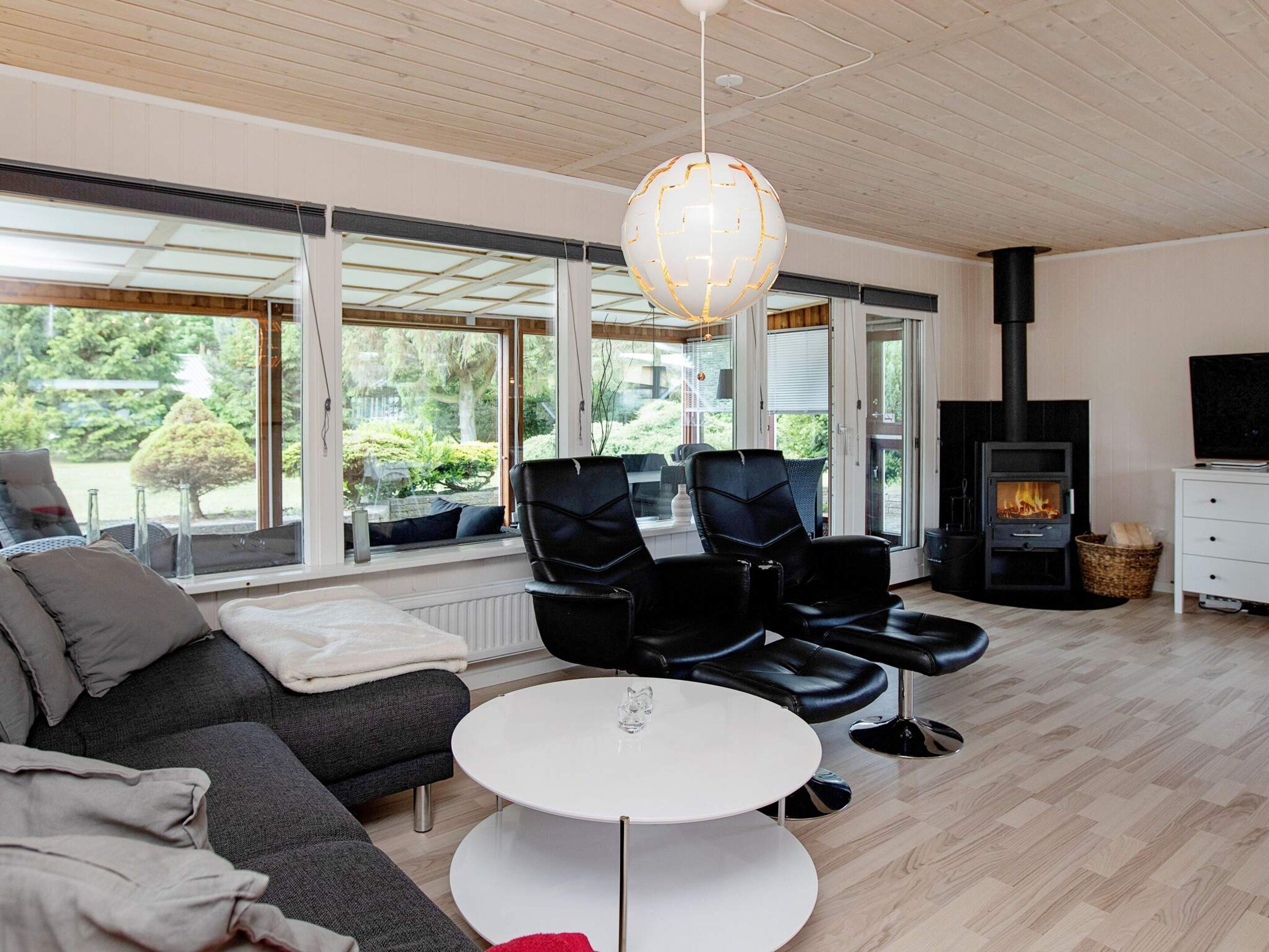 A modern living room with a fireplace, a sofa, a coffee table, and a TV.