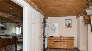 A kitchen with a wooden cabinet, a tiled floor, and a door leading to another room. - 12 Person Holiday Home in Hojer (Højer)