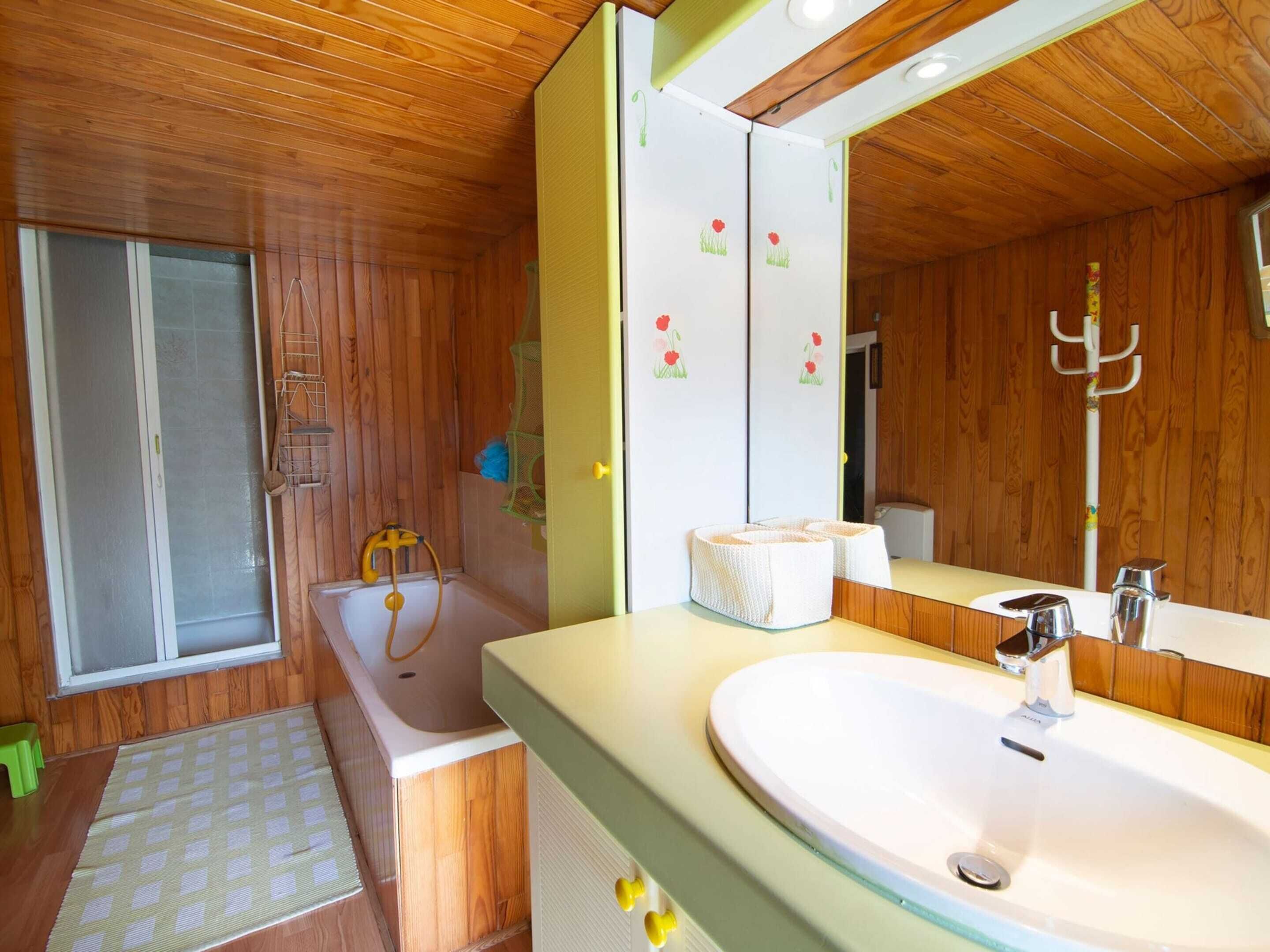 A bathroom with a bathtub, a sink, and a mirror.