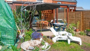 Un jardin avec un patio couvert, un espace salon extérieur et un coin aménagé.