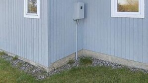 Een gebouw met één raam en een installatiekastje aan de buitenmuur.