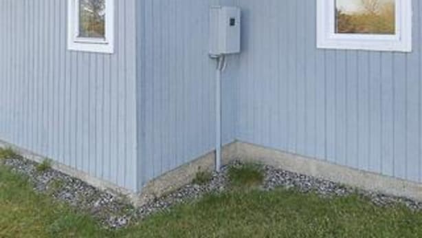 Un bâtiment doté d’une seule fenêtre et d’une boîte de raccordement fixée sur le mur extérieur.