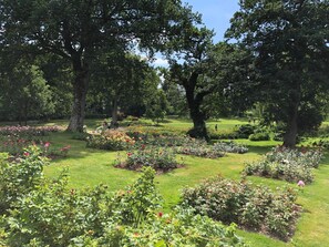 Een park met diverse bloembedden en bomen.