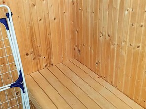 A wooden room with a metal rack and a bench. - Holiday Home in Gravdal (Grasten)