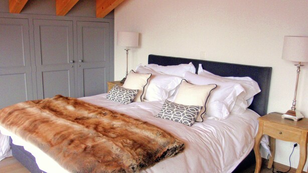 A bedroom with a large bed, two bedside tables, and a wooden headboard. - Lavish Holiday Home in Heremence With Balcony (Heremence)