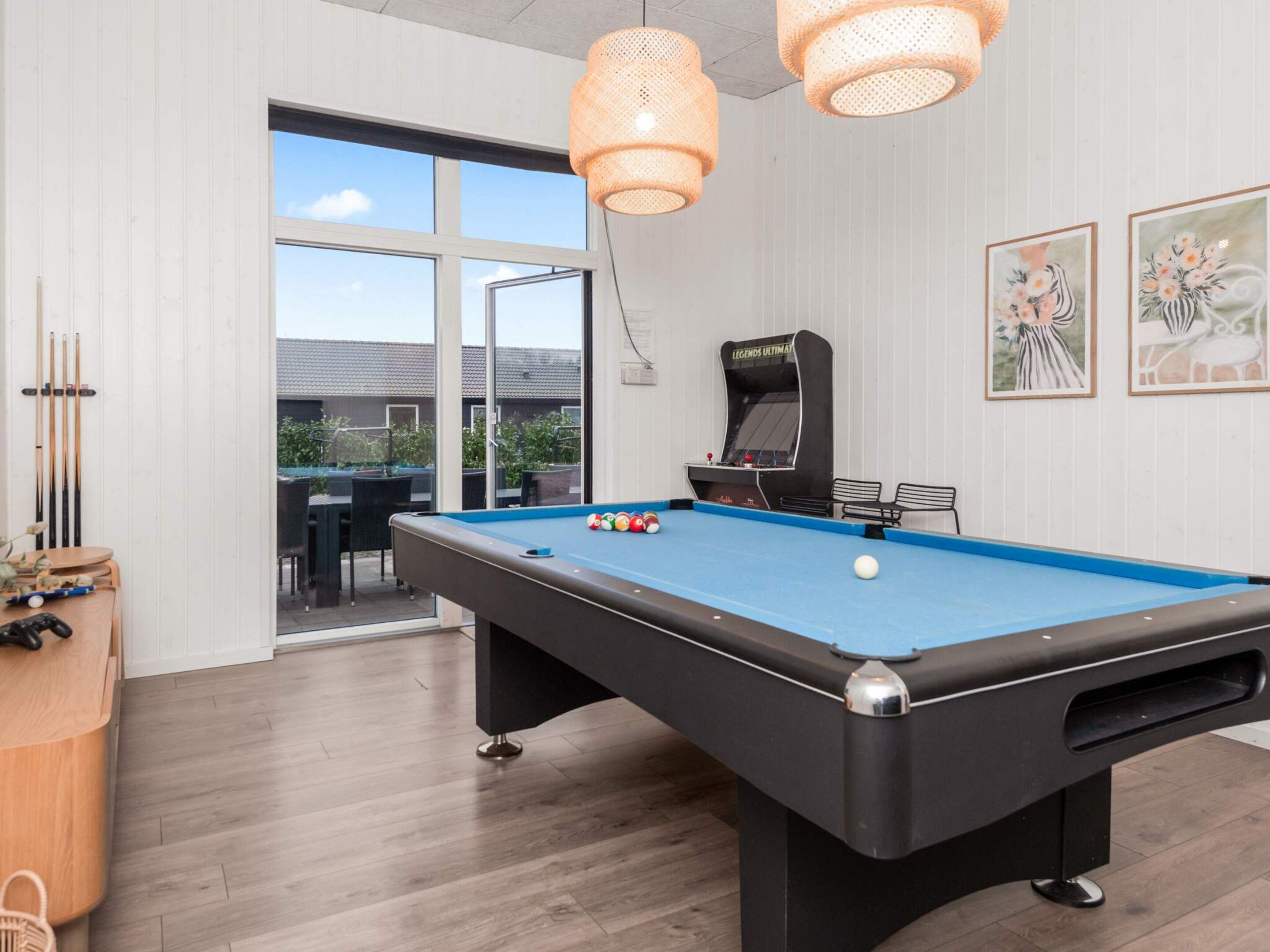 A pool table with balls, a pool cue rack, and a table tennis table.