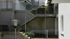 A multi-level residential building with external staircases, metal railings, and a light fixture. - Grosse Ferienwohnung in Willingen mit Balkon (Willingen)