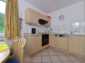 A kitchen with wooden cabinets, a microwave, a coffee maker, and a dishwasher.
