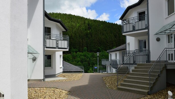 A pathway leading to a building with a balcony and a staircase. - Grosse Ferienwohnung in Willingen mit Balkon (Willingen)