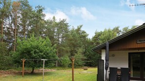 Une cabane avec une façade en bois, une véranda avec deux chaises et une enseigne sur laquelle on peut lire « Winds ».