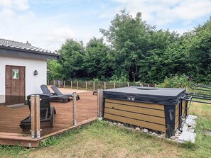 A wooden deck with lounge chairs, a hot tub, and a small building with a door. - Holiday Home in VÃ¦ggerlÃ¸se (Vaeggerlose)