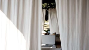 A bedroom with a bed, curtains, and a view of the outdoors. - Apartment in Marche Near Sibillini Park (Ripatransone)