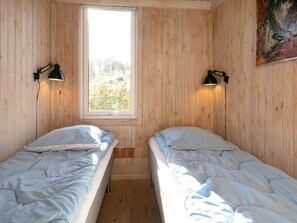 A room with two single beds, wooden walls, a window, and two wall-mounted lamps. - 10 Person Holiday Home in Slettestrand Fjerritslev (Fjerritslev)