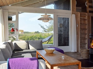 Una sala de estar acogedora con un sofá, una mesa de centro y vistas al exterior.