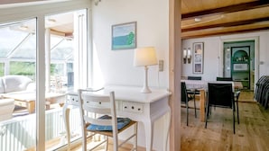 A bright room with a white desk, a chair, and a lamp. There is a window with a view of greenery outside. - 16 Person Holiday Home in Ulfborg (Ulfborg)