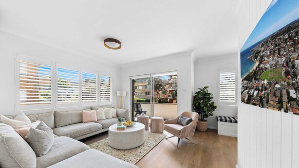 A spacious living room with a large sofa, a round coffee table, and a view of the sea through large windows. - Coogee by the Coast  (Coogee)