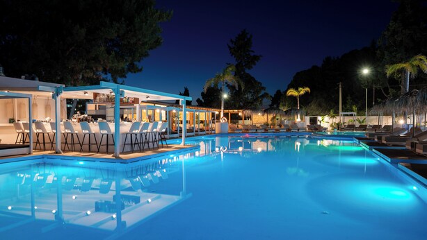 Una piscina con sillas de descanso y una zona de bar.