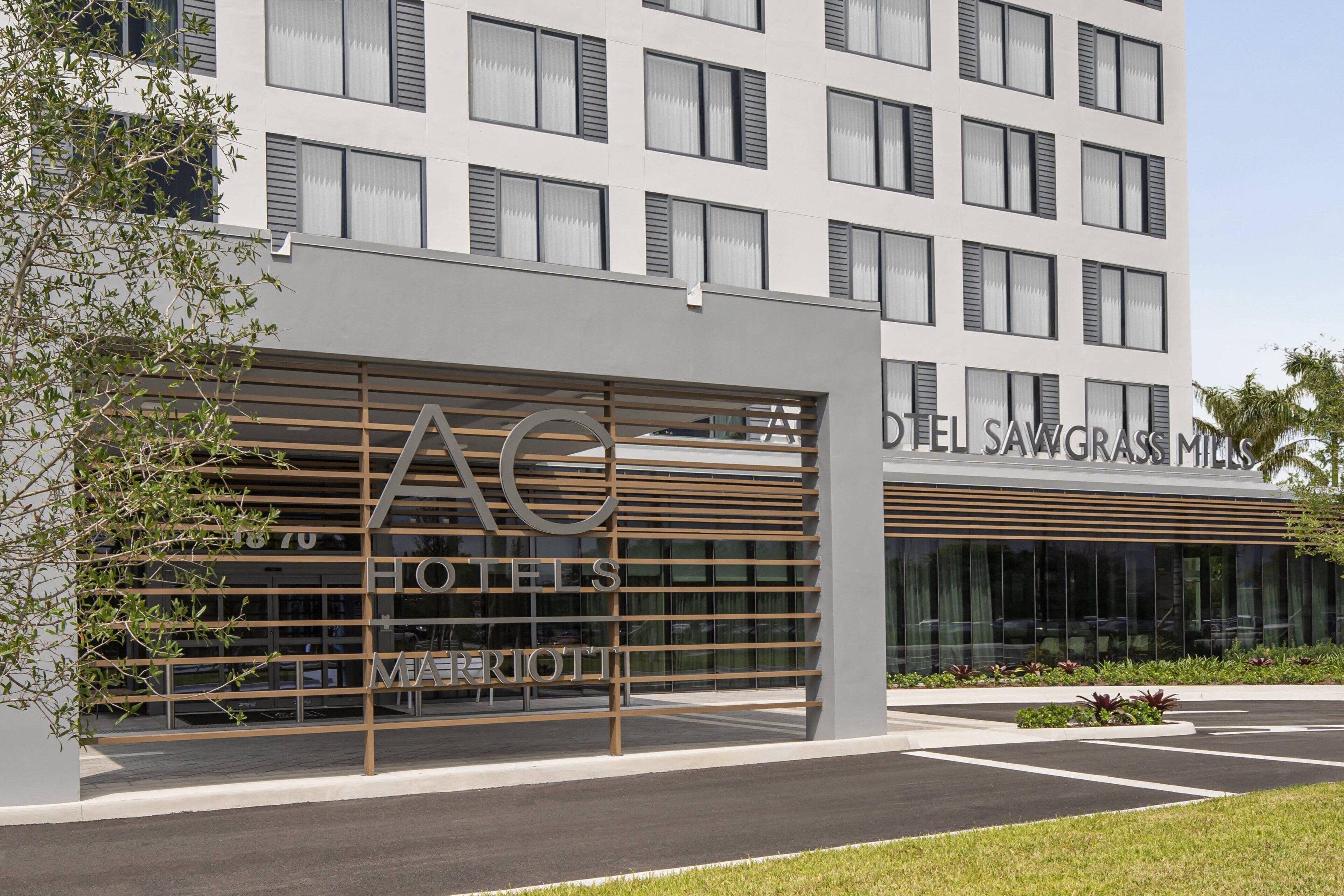 Un hotel moderno con un cartel grande que dice "HOTEL SAVGRASS MILLS".