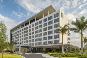 A modern hotel with a flat facade, multiple windows, and a covered entrance area. - AC Hotel Fort Lauderdale Sawgrass Mills / Sunrise (Sunrise)