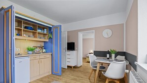 A compact living space with a kitchenette, dining area, and a TV.