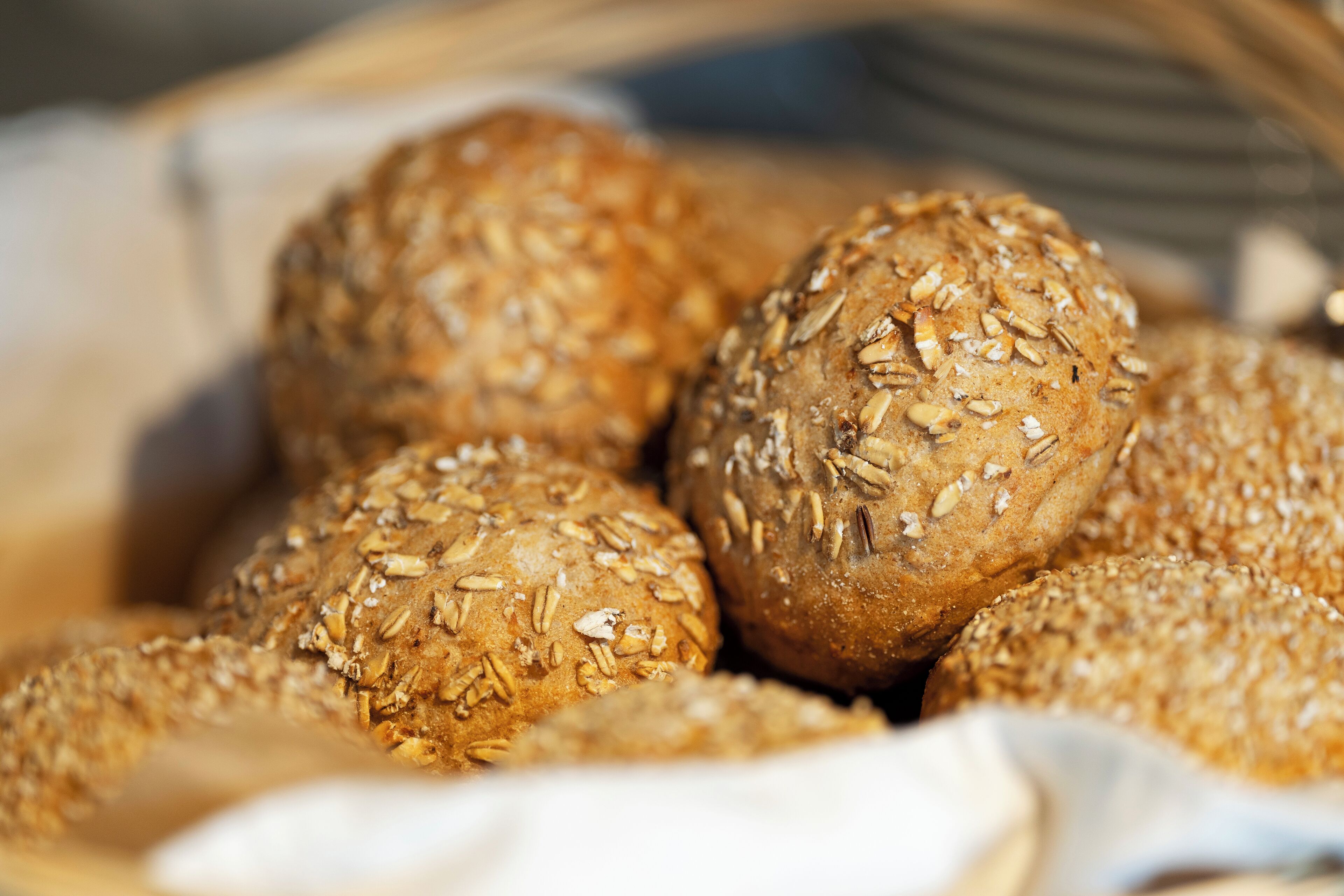Ein Korb mit runden Brötchen, bestreut mit Sesam.