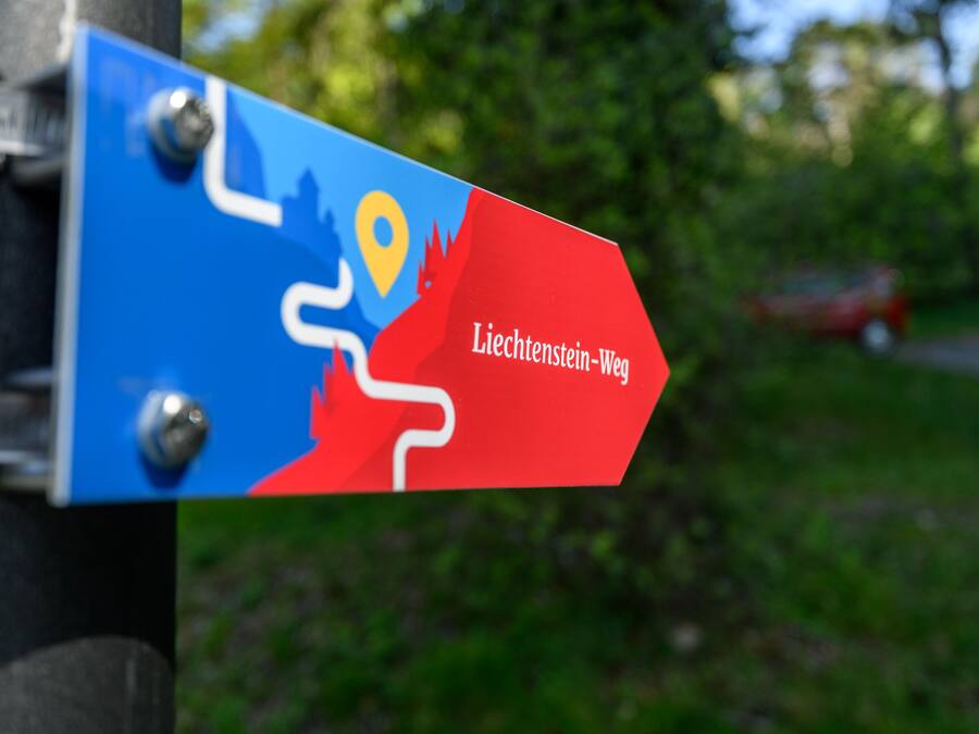 Uma placa indicativa com um mapa e o texto 'Liechtenstein-Wien'.