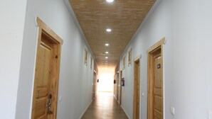 A hallway with wooden doors and a wooden ceiling. - Le ROI Floating Huts & Eco Rooms (Tehri)