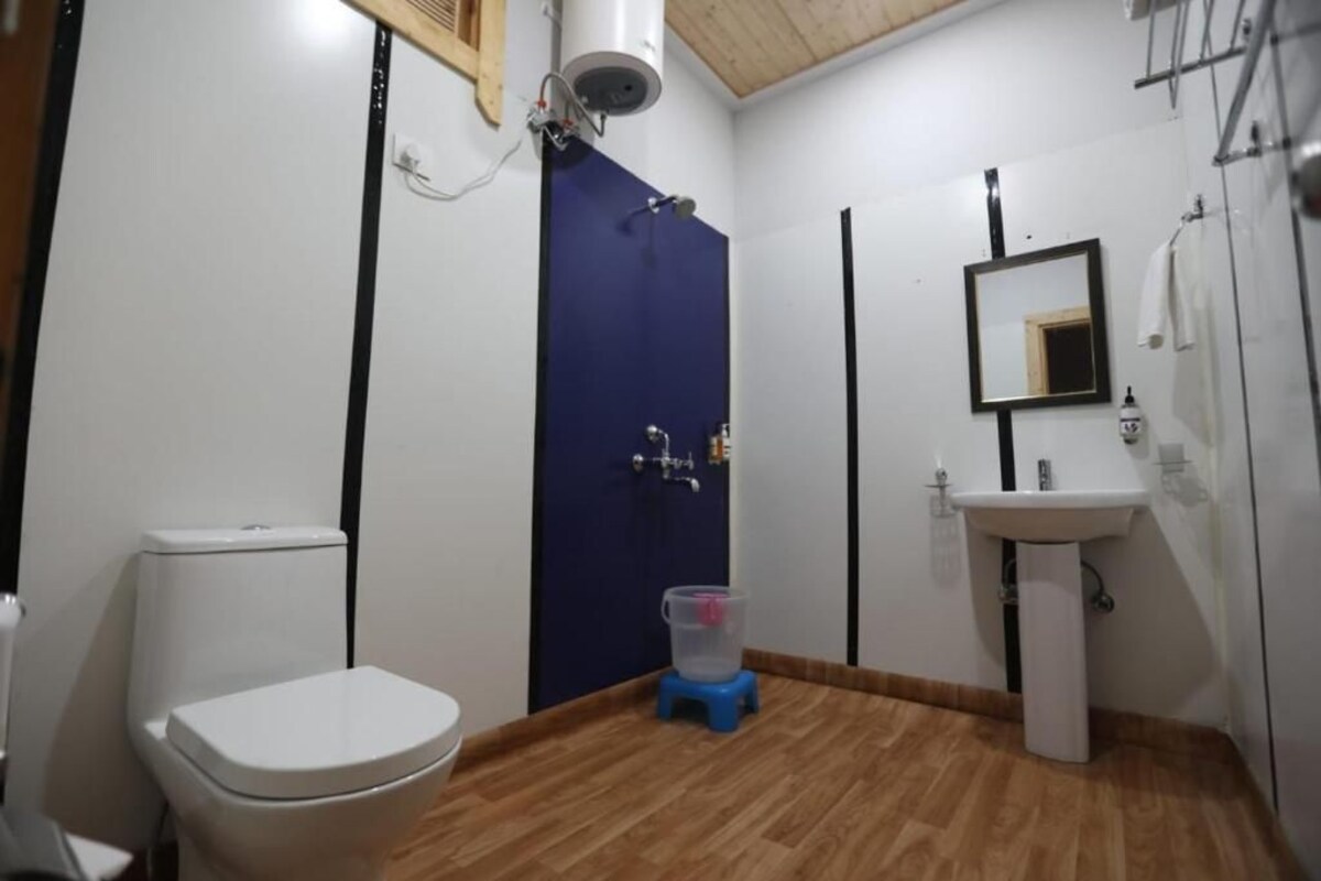 A small bathroom with a toilet, a sink, and a shower.