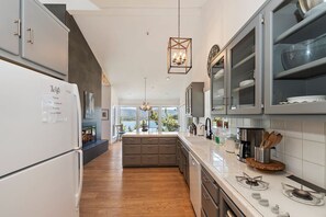 A modern kitchen with a built-in oven, a gas stove, and a large island with a sink.