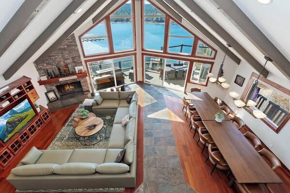 A spacious loft with a large skylight, a cozy seating area, a fireplace, and a dining table.