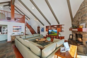 Una sala de estar amplia con un sofá modular grande, una chimenea y un televisor.
