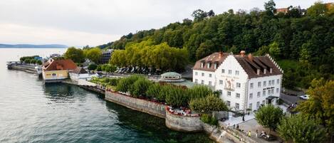 Une ville riveraine qui se distingue par un imposant bâtiment blanc, un pont et une promenade en bord de mer.