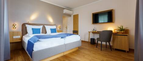 Une chambre d’hôtel moderne avec un grand lit, un bureau et une télévision.