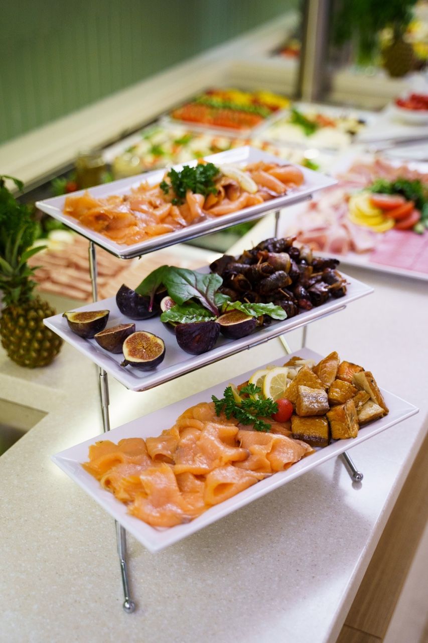 A buffet with various food items including salmon, figs, and vegetables.