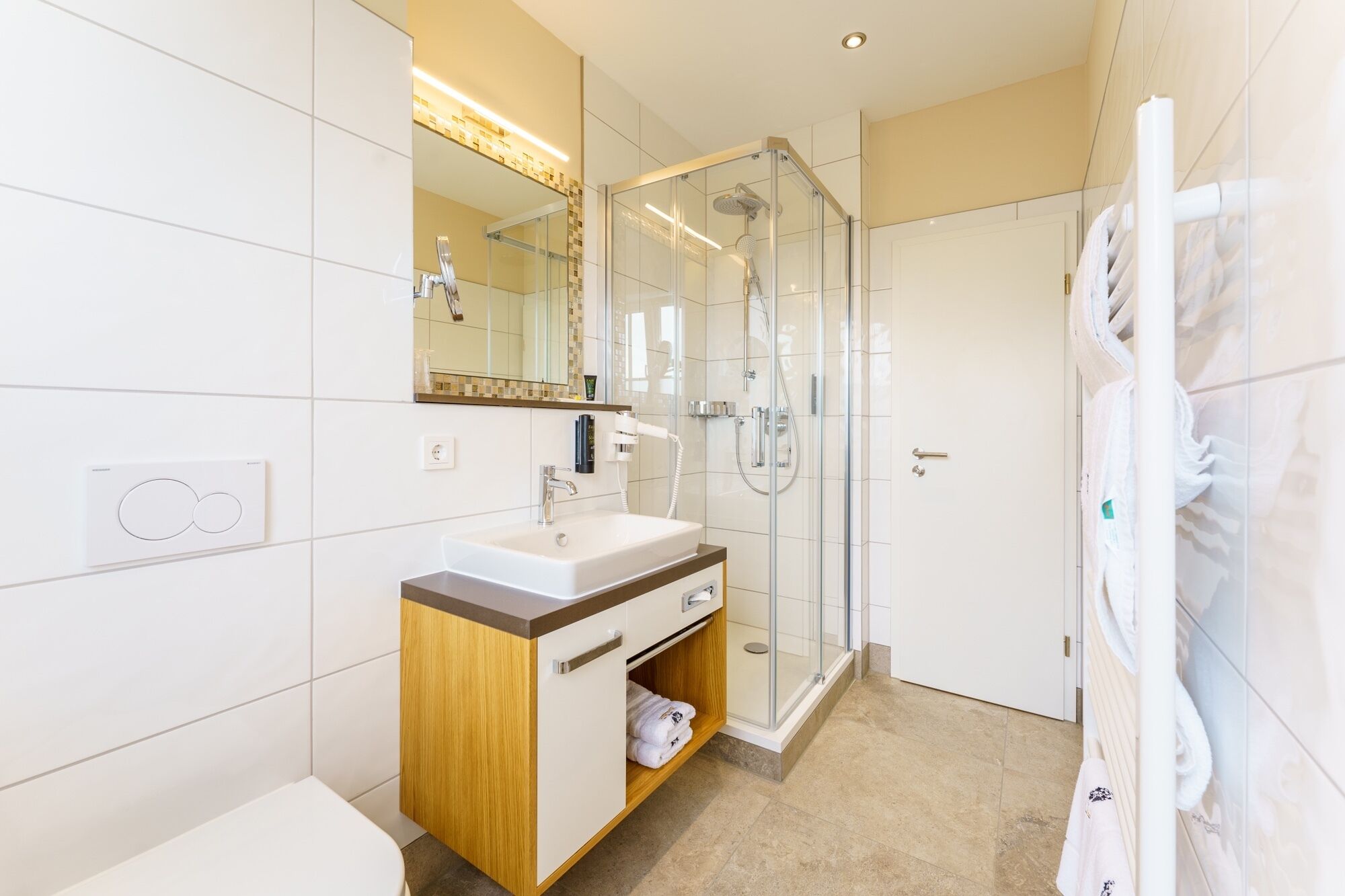 A modern bathroom with a glass-enclosed shower, a sink with a vanity, and a towel rack.