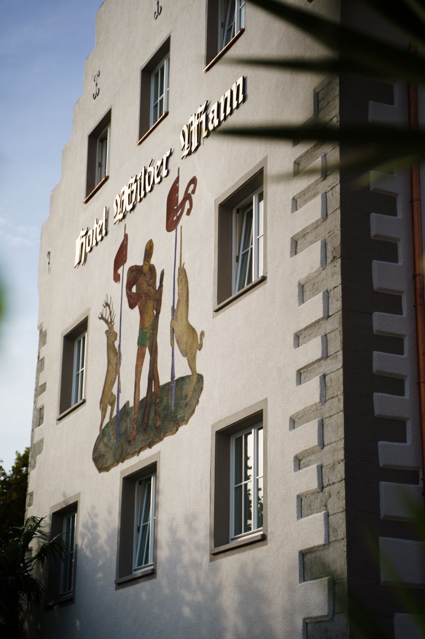 Un edificio con un letrero que dice 'Hotel' y un mural con figuras y animales.