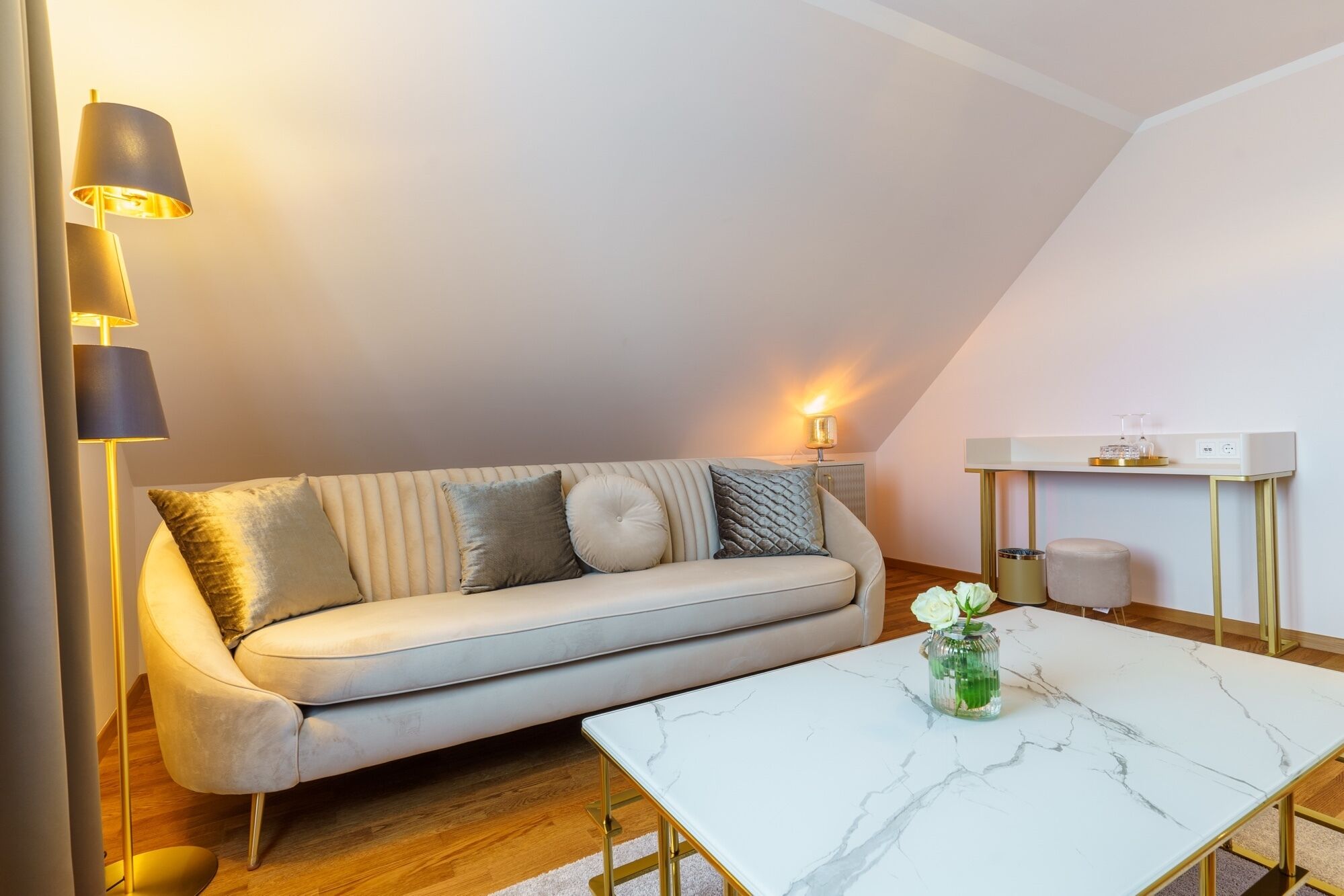 Un salon moderne avec un canapé, une table basse en marbre et un lampadaire.
