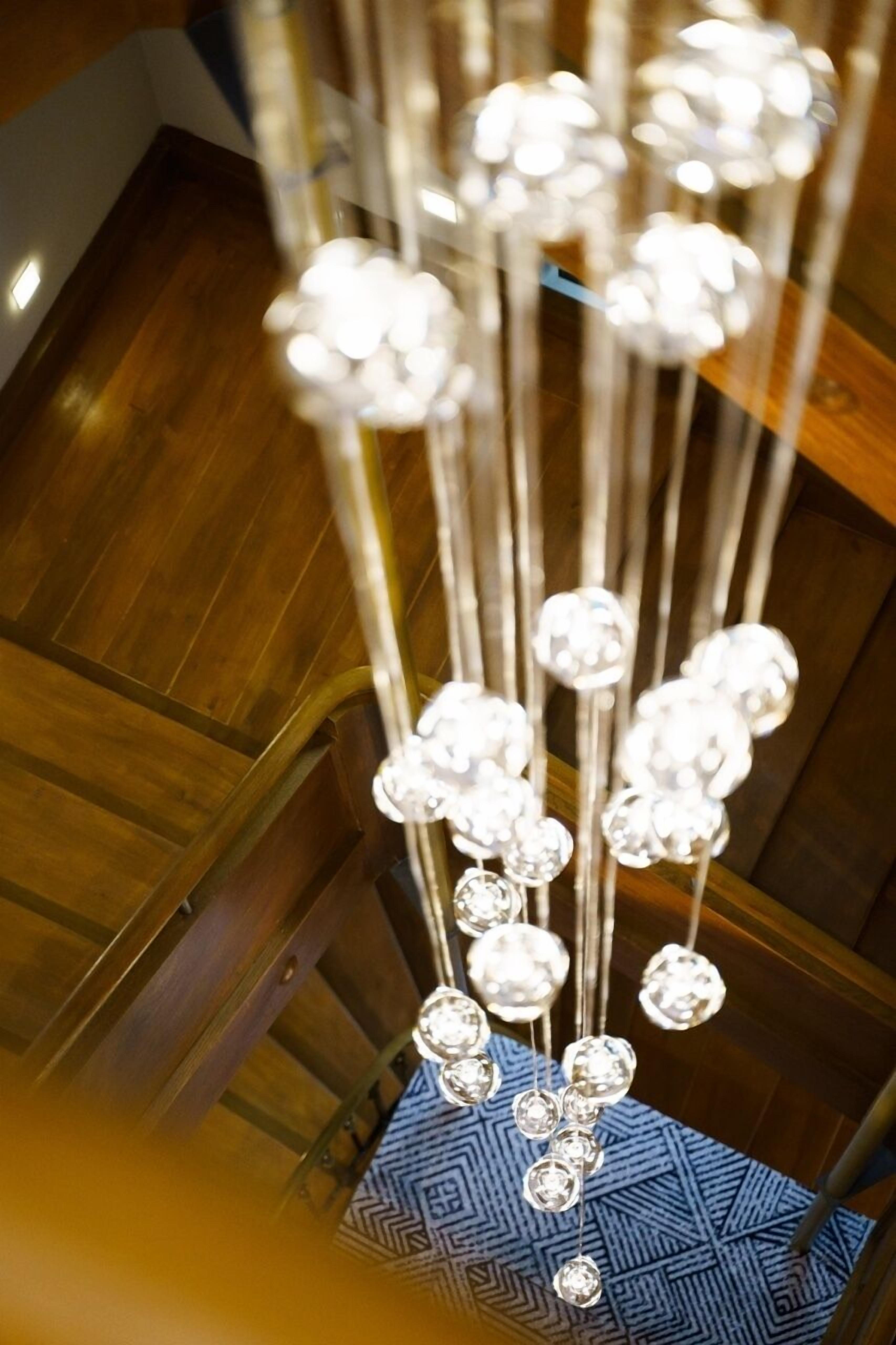 A chandelier with multiple crystal-like elements hanging from a metal structure.