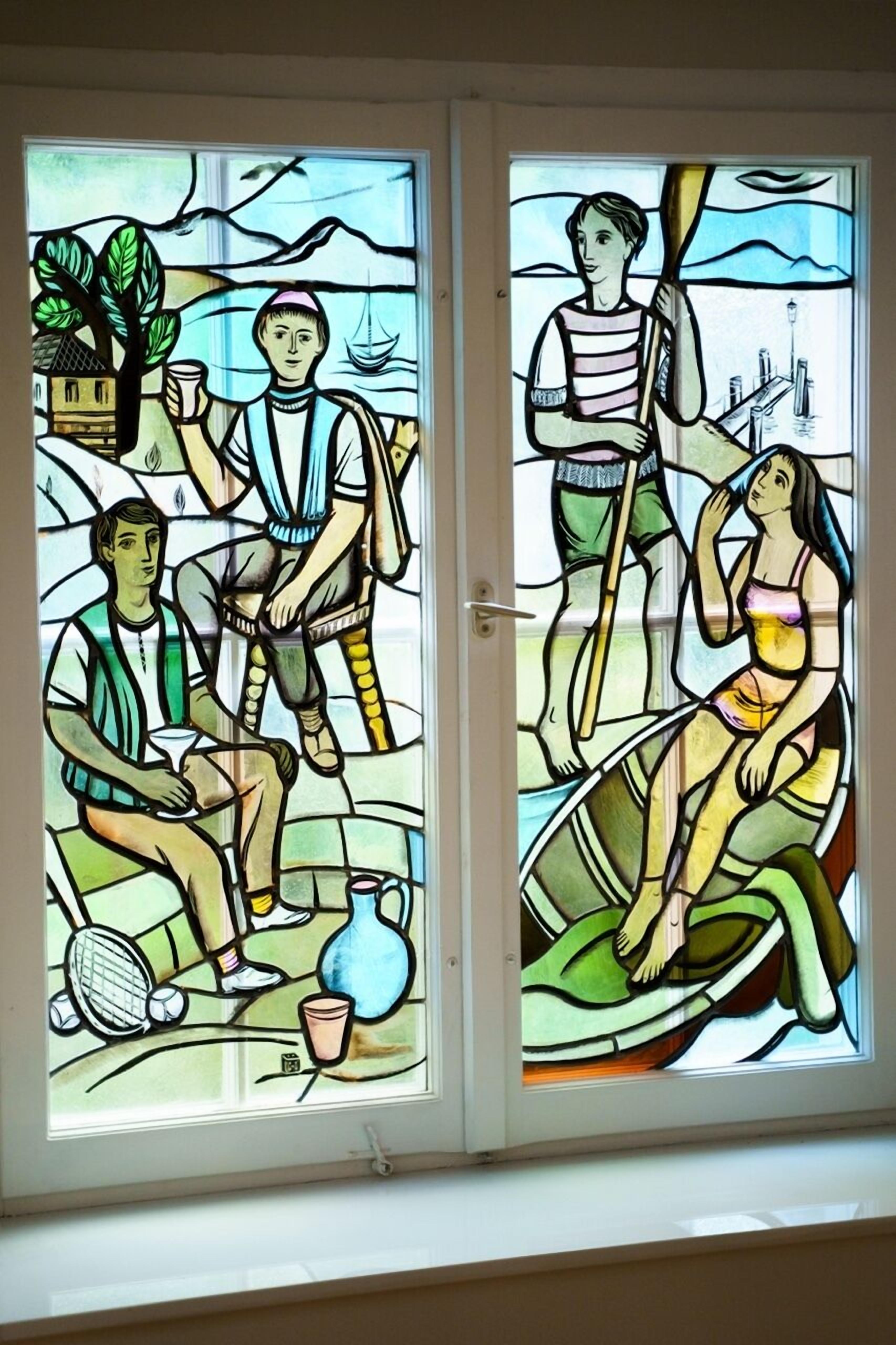 A stained glass window with two panels depicting people in a relaxed setting.