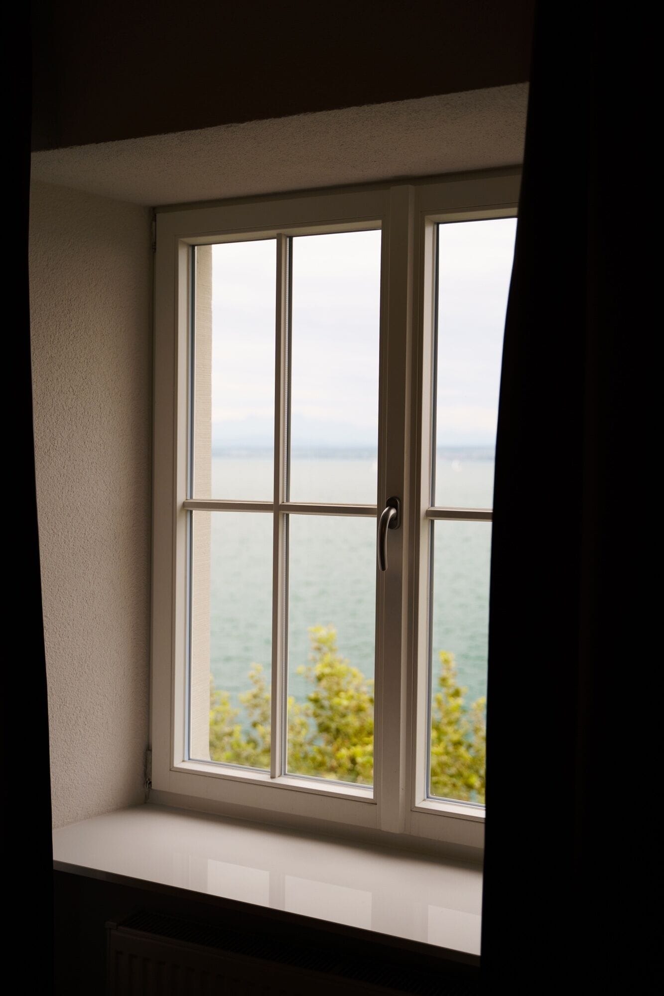 Une fenêtre donnant sur la mer et la verdure.